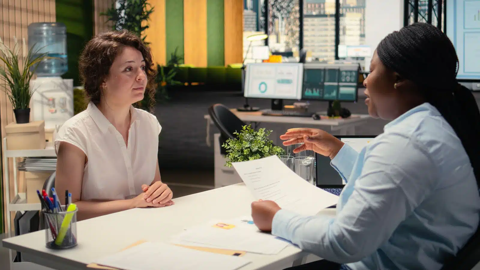 An HR representative onboards a new employee, explaining the benefits package.