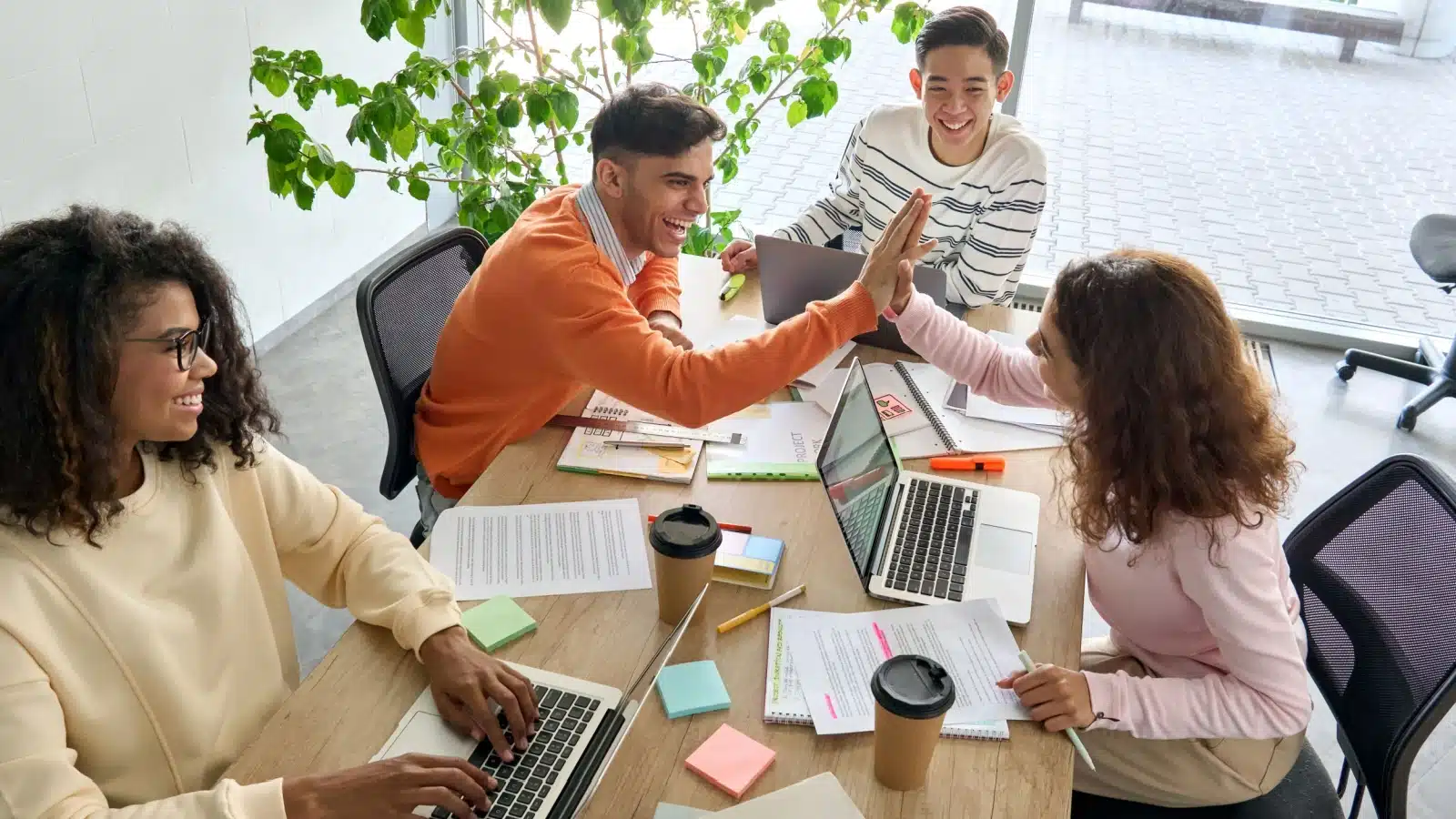 A group of happy Millennials at work completing a project, to represent Millennials Skills