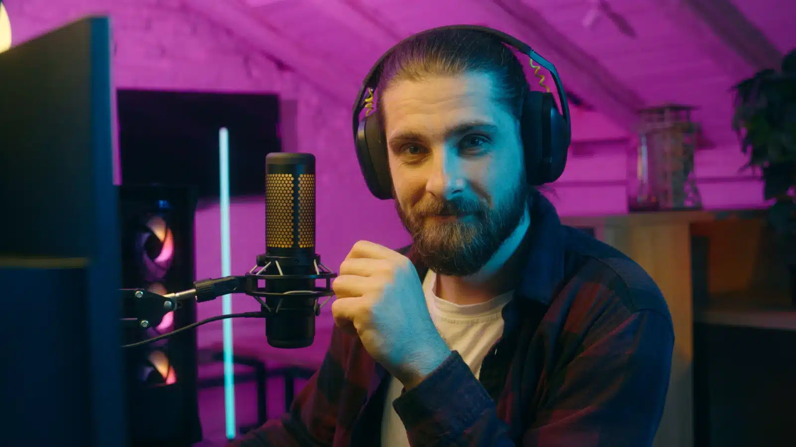 A contemplative streamer with his headset and microphone to represent popular Twitch categories for streaming.