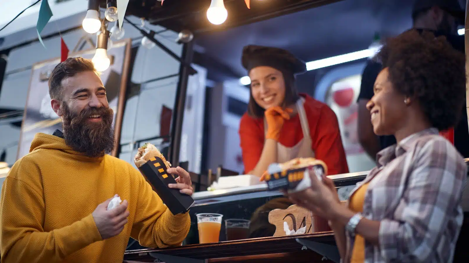 Strangers chat after receiving their orders from a food truck.