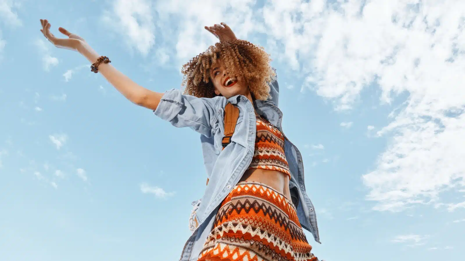 A happy woman enjoys a beautiful day outside, carefree.