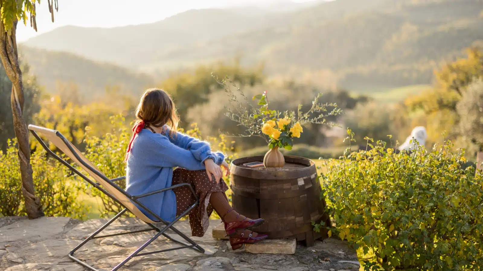 A woman sits in a field, enjoying the moment.
