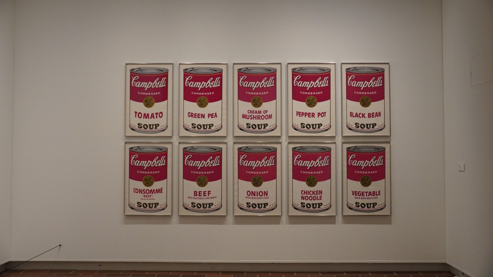 Exhibit of Andy Warhol's soup can paintings on display in a musuem.