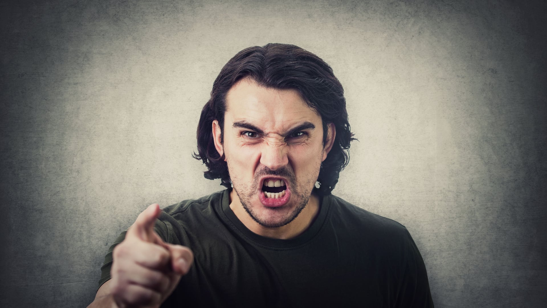 Angry man yelling and pointing his finger towards the camera