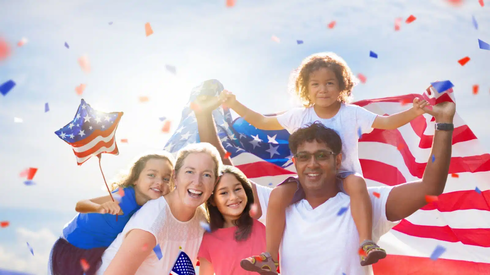 A diverse family waving the American flag to represent the best American traditions.