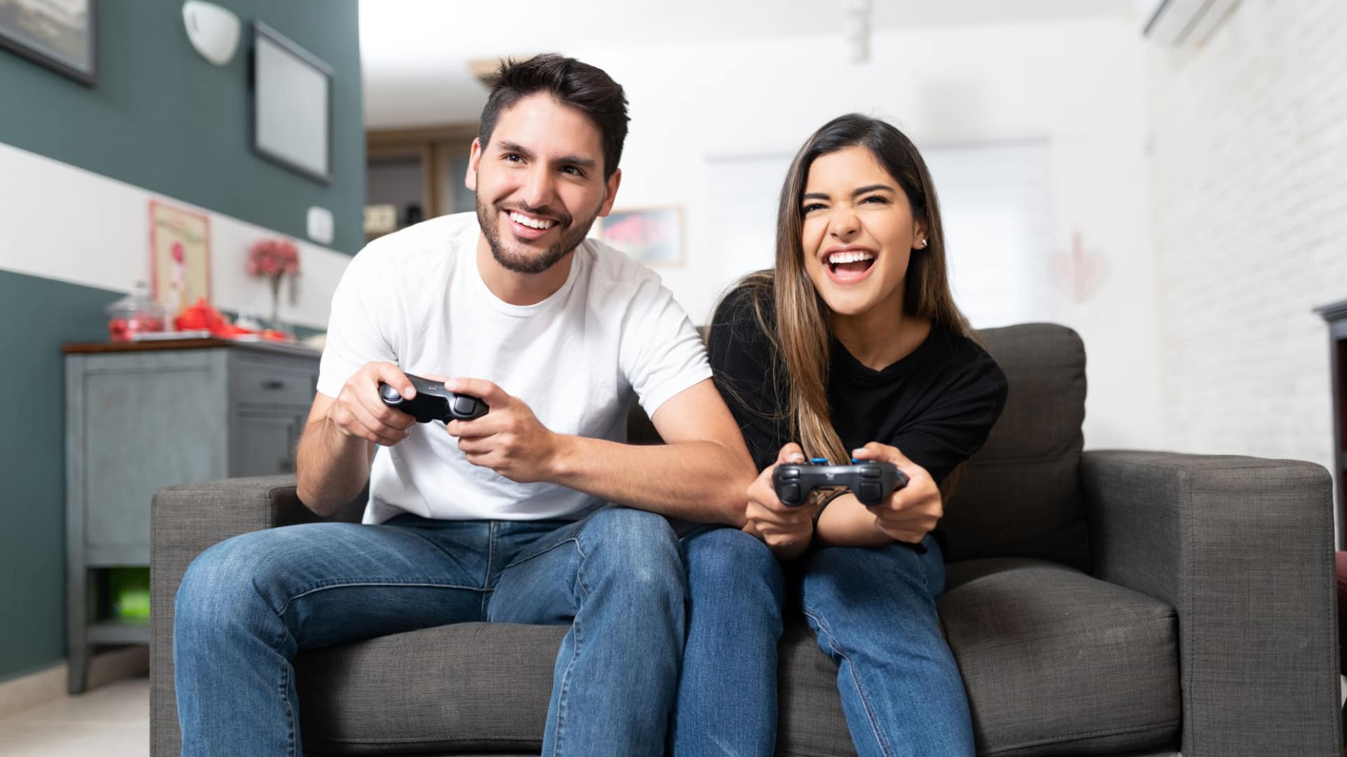 Couple on the couch gaming to represent the best video games of all time.