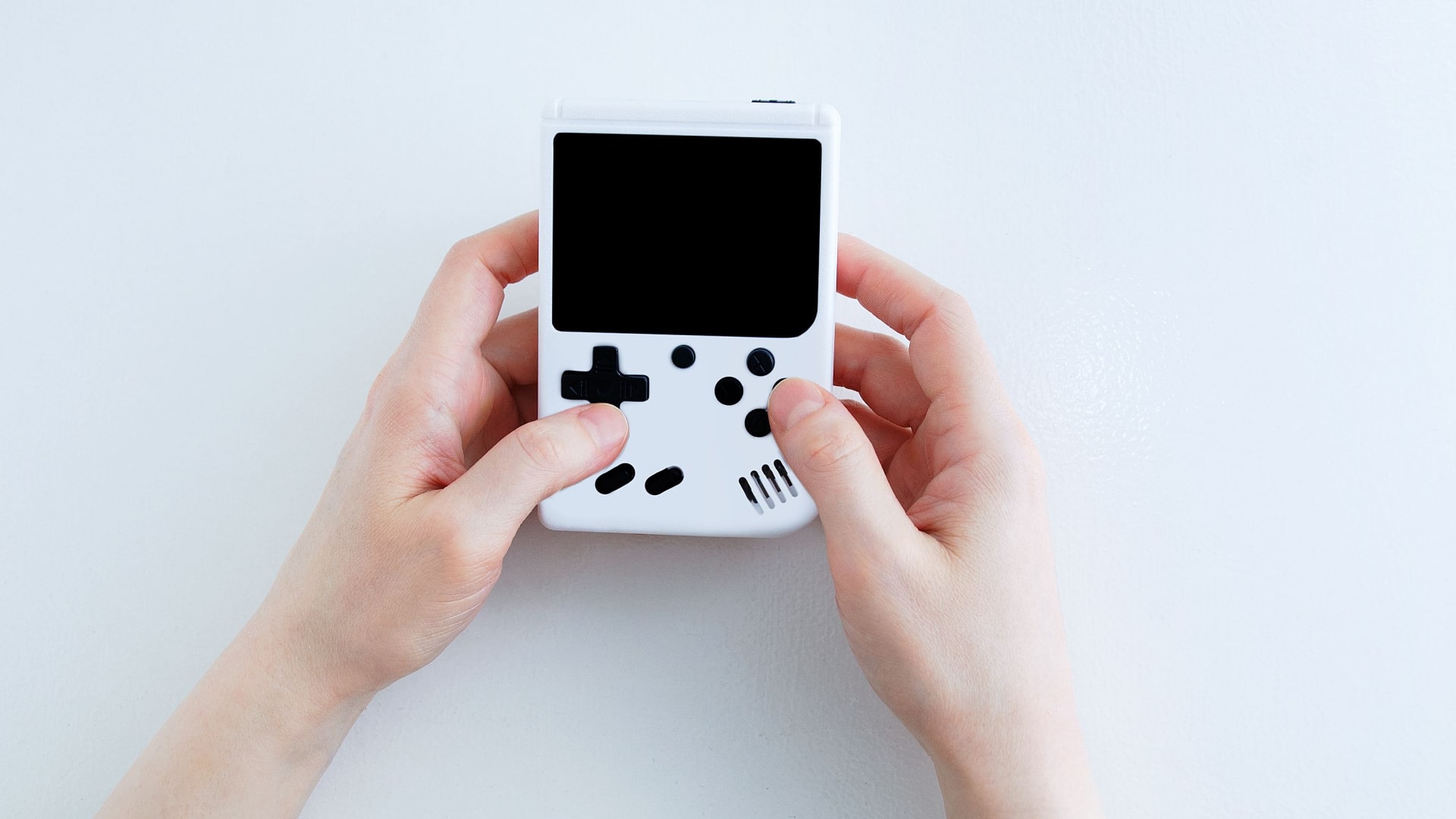 hands holding a simple, generic handheld game that looks like an old gameboy