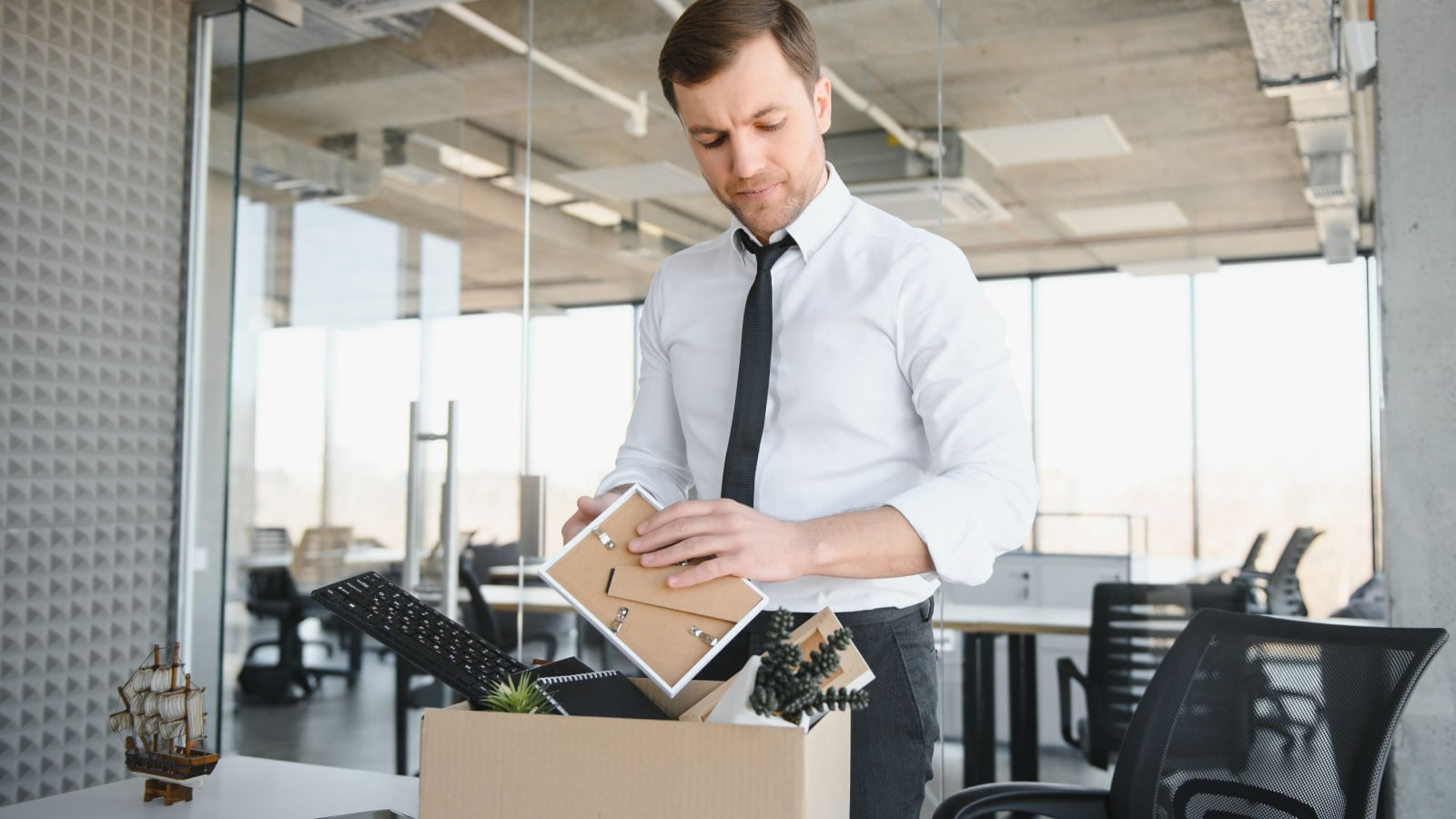 A worker packs up his desk after a layoff to represent jobs that no longer exist.