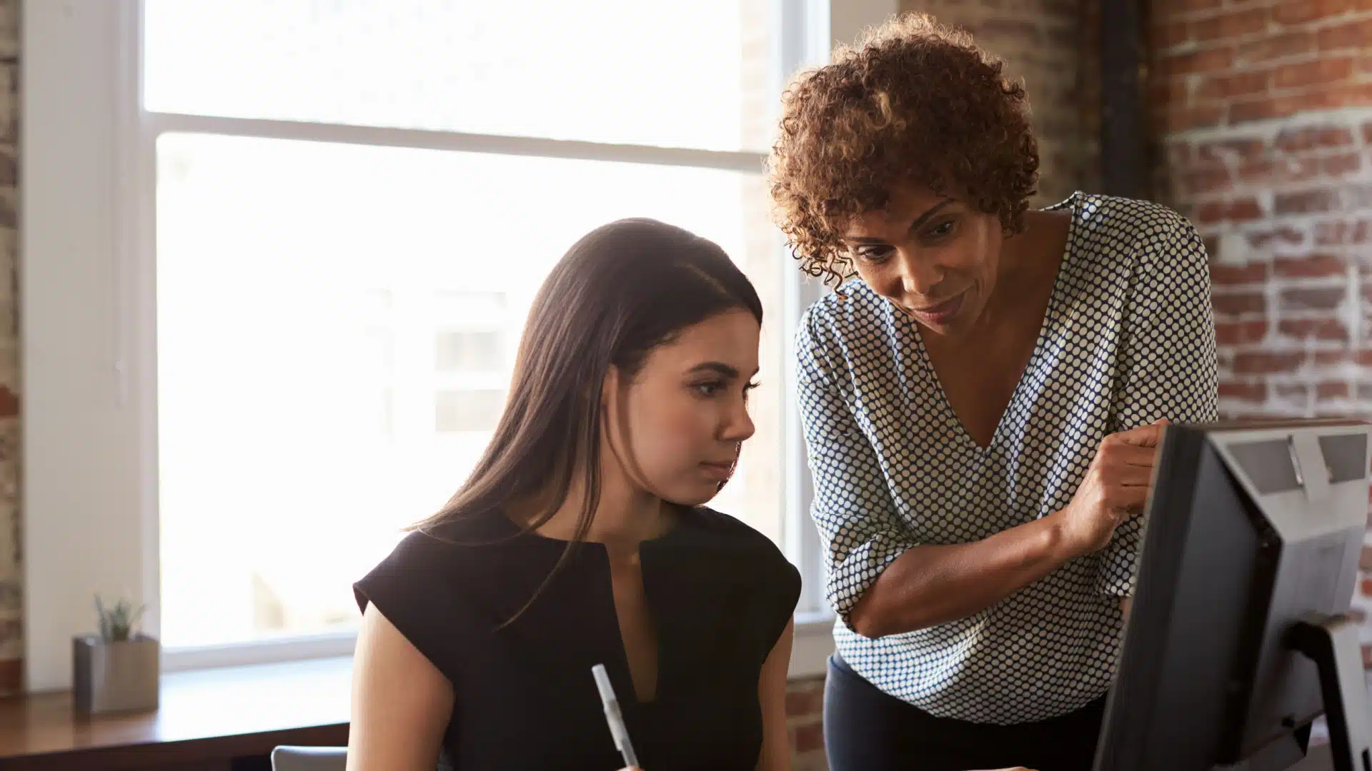 older woman mentoring younger collegue