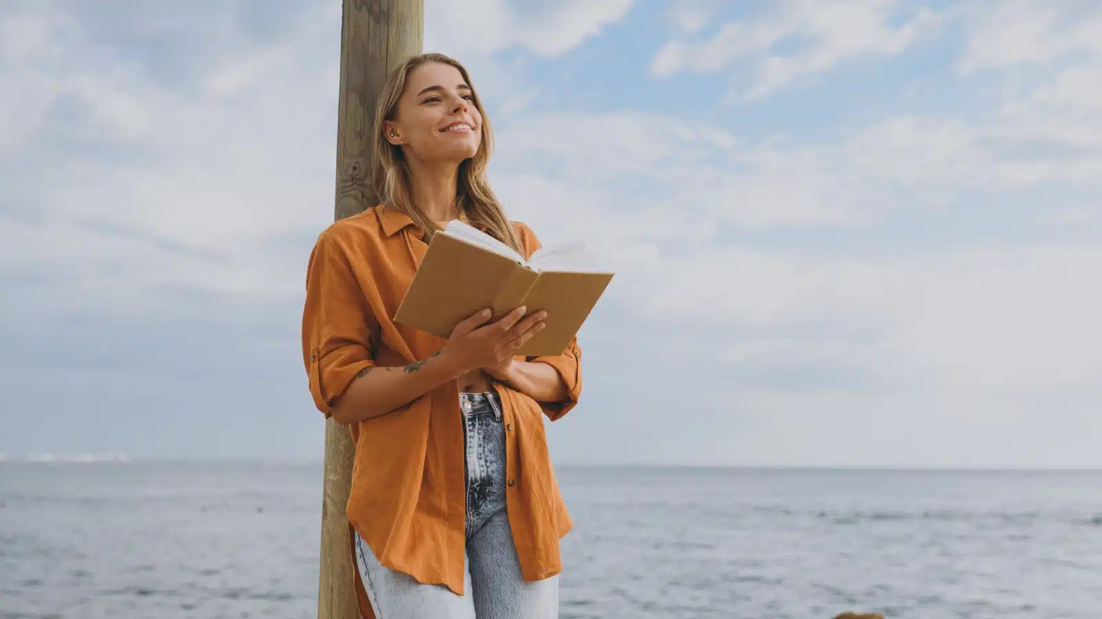 A woman practices mindfulness while she journals outside.