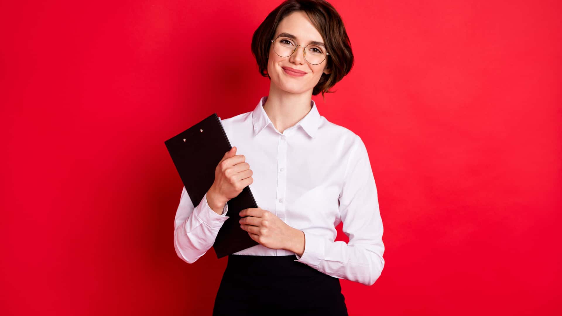 Professional woman holding clipboard on a bright red background