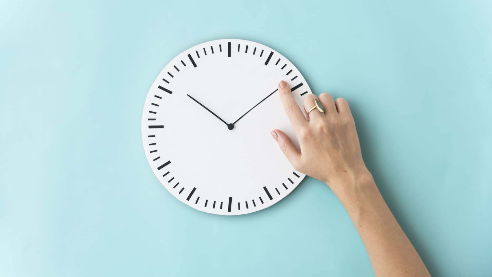 hands setting the minute hand on a clock