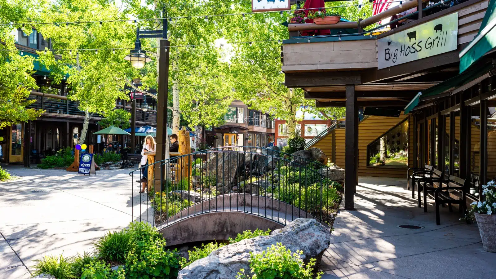 Aspen, USA - June 24, 2019: Snowmass village town in Colorado downtown with big hoss grill restaurant and small garden park with bridge.