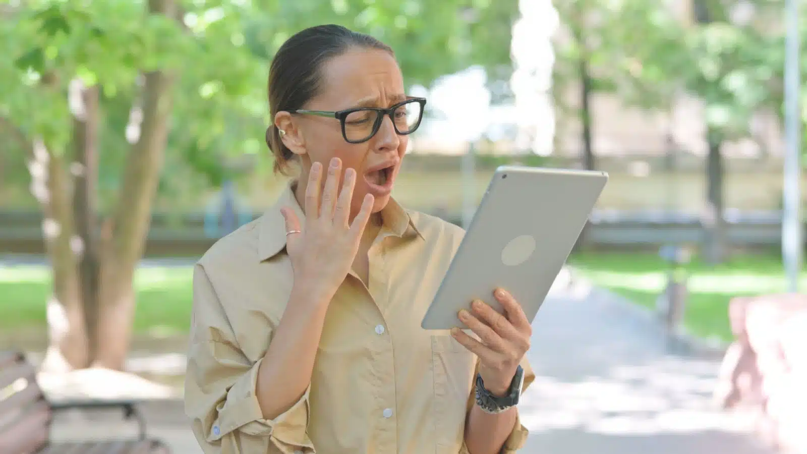 A woman is appalled by what she reads on her tablet.