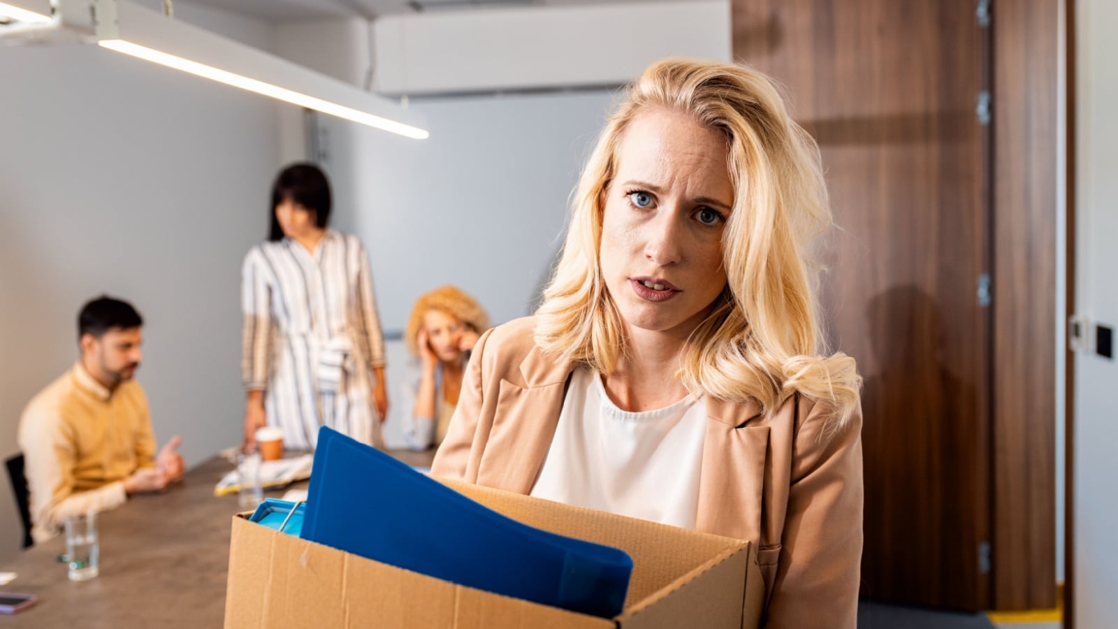 A woman carried a box of personal belongings after she was fired from her job to represent how bad economies affect women.