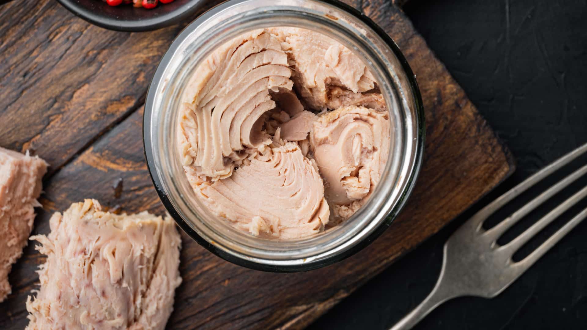 closed up of canned tuna with a fork next to it.