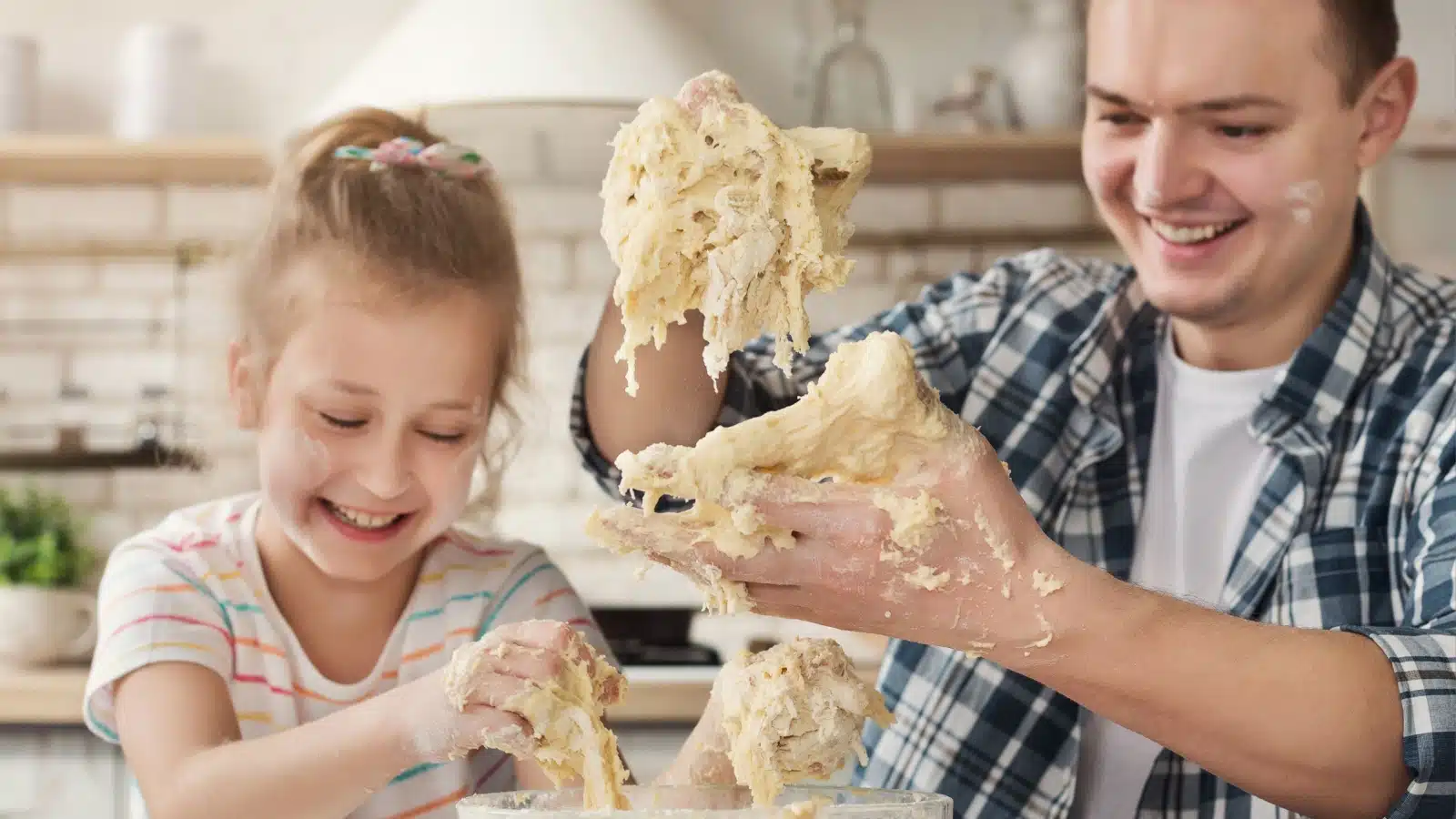 A father and daughter laugh about the mess they made trying to make cookies.
