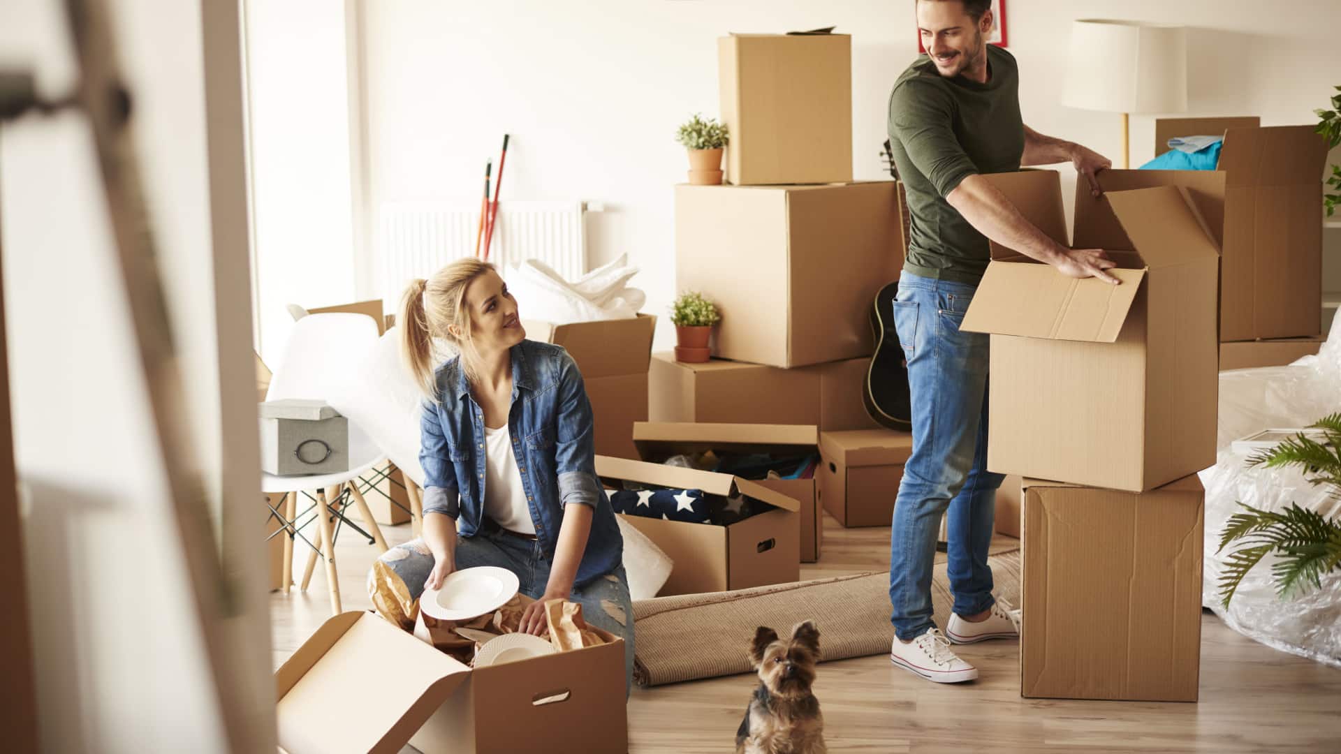happy couple packing their house into boxes getting ready for a move.