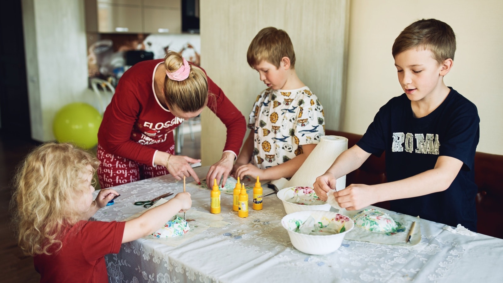 A family doing crafts together using papier mache.