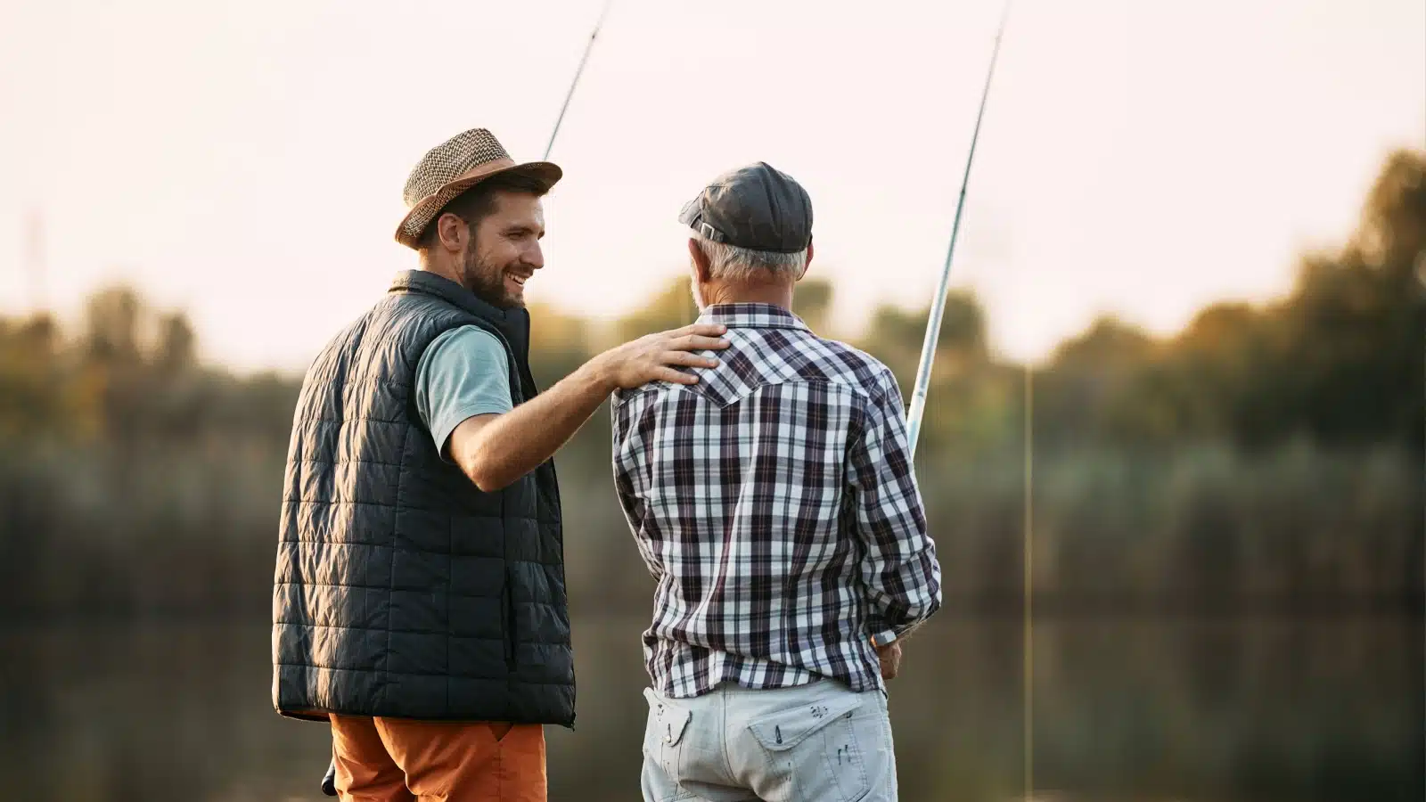 A father and his adult son enjoy fishing together.
