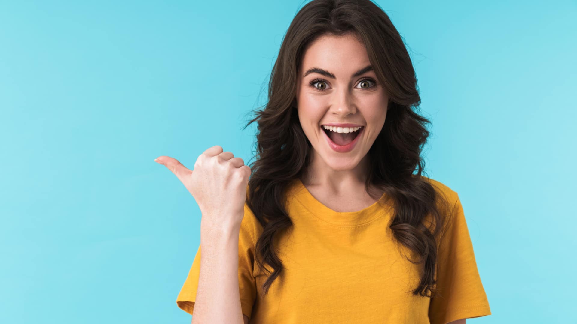 Happy woman pointing behind her right shoulder with her thumb.