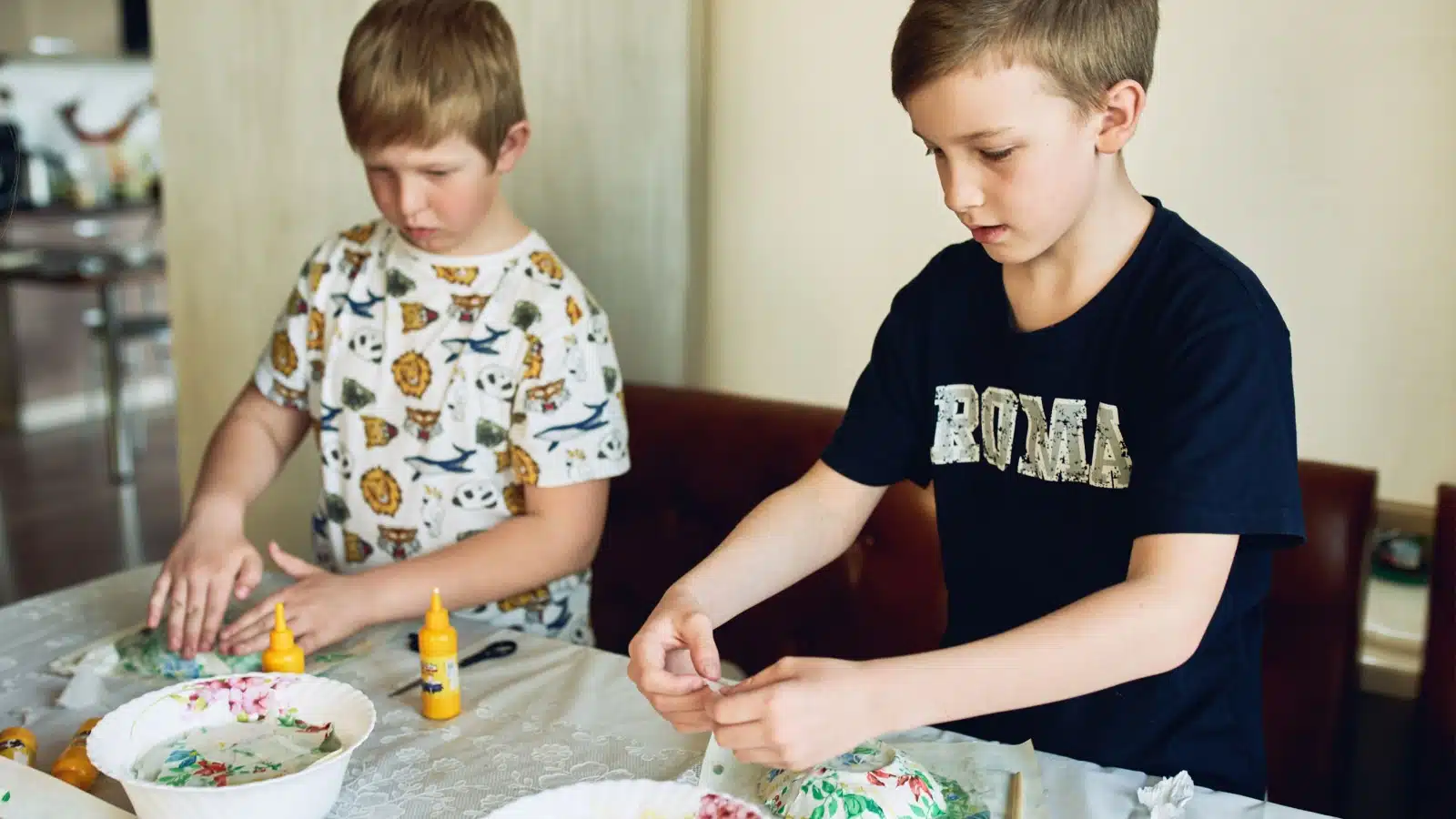 Kids using papier mache to make a project.