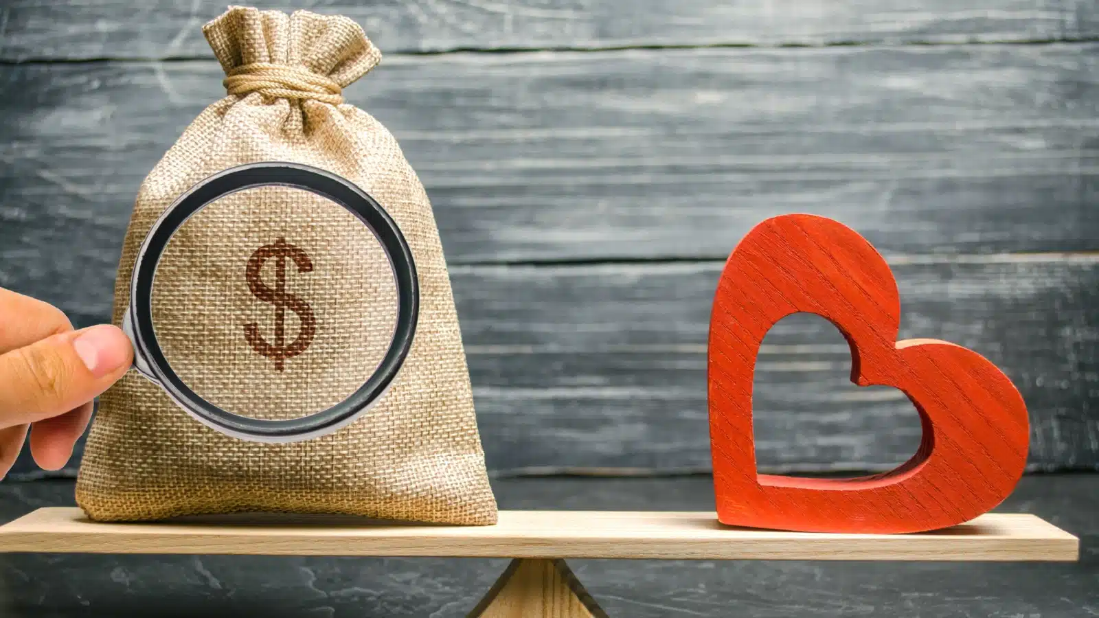 A balancing scale with a bag of money on one side and a heart on the other. Is money the most important thing, or should you balance it with the things you love?