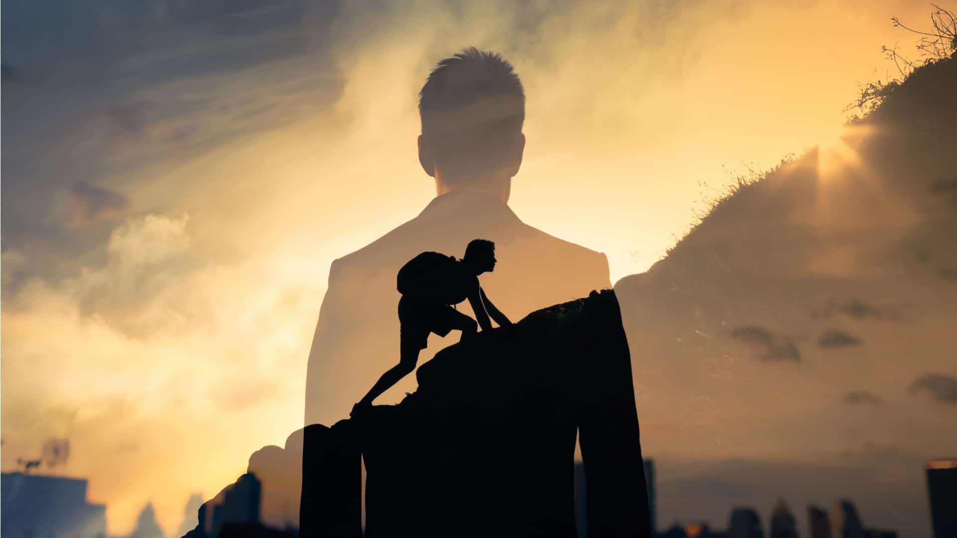 Silhouette of man climbing mountain with his shadow watching to represent motivation 