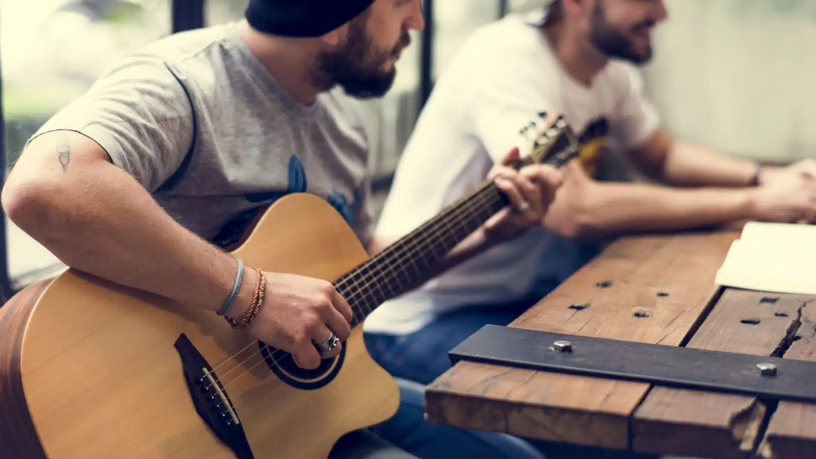 A man practices playing music on his guitar.