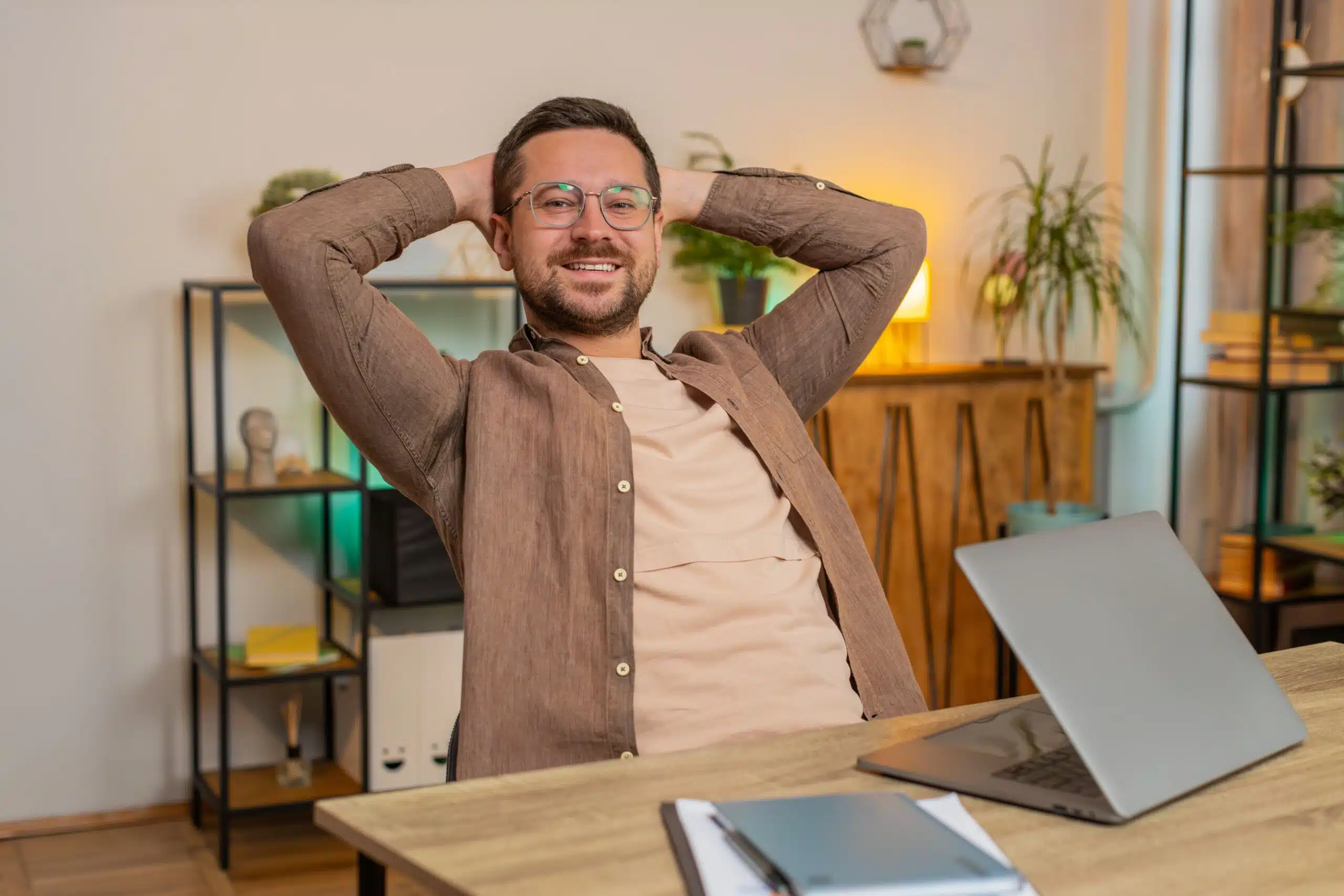 A man relaxes after he's finished working on his laptop for the day.