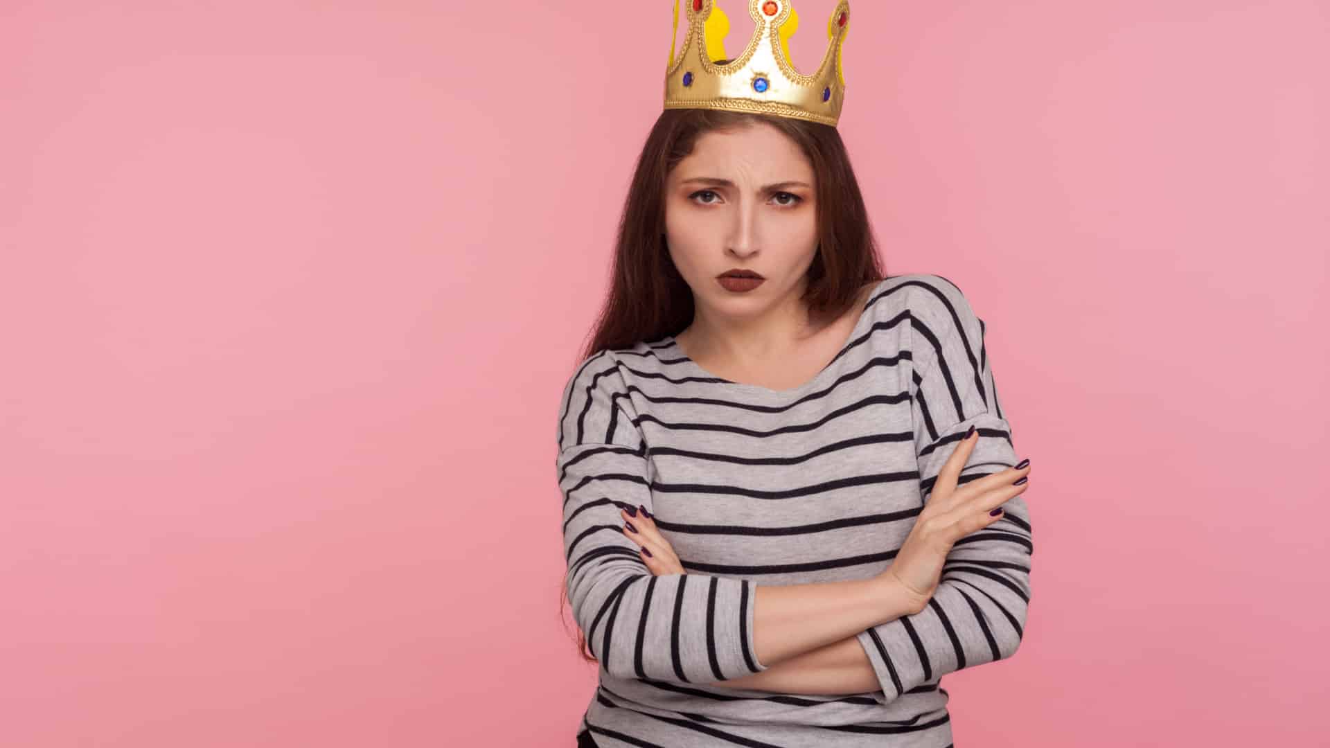 Arrogant looking woman wearing a crown. She represents the warning signs of a selfish person.