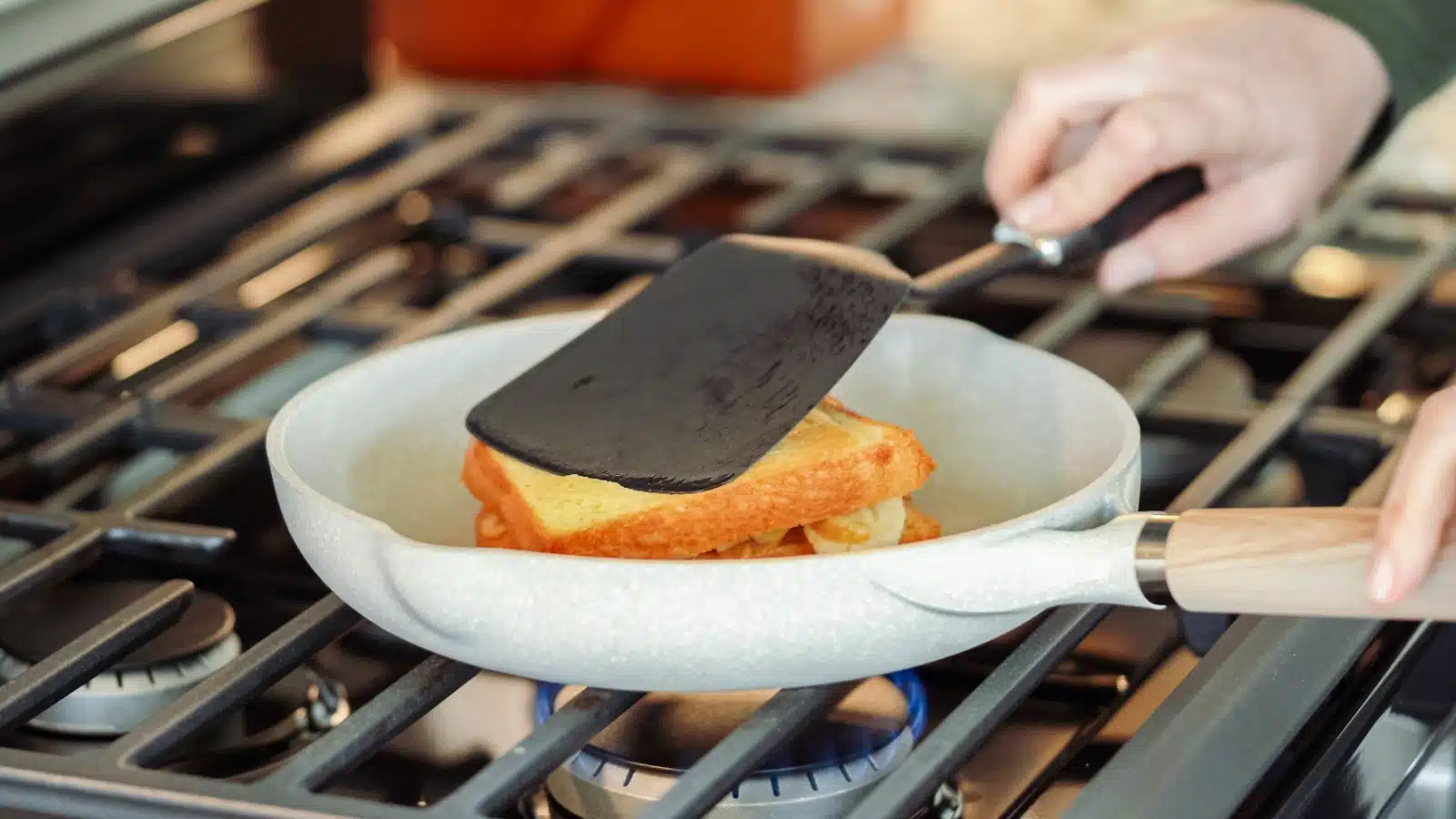 A person cooks a grilled cheese sandwich on medium heat.
