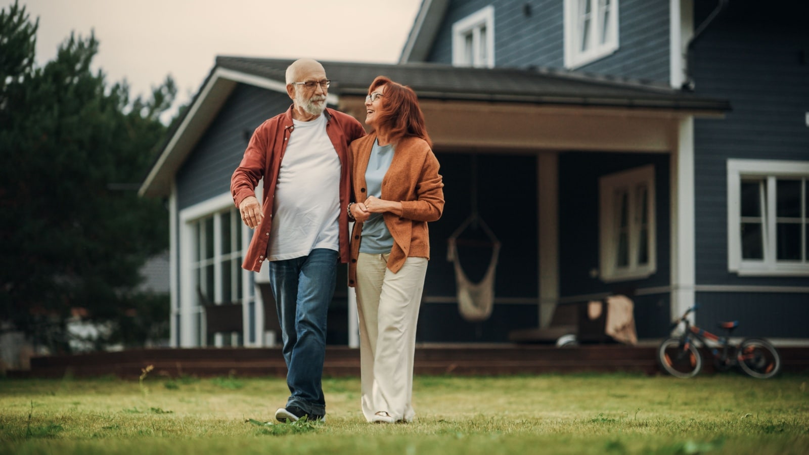 A happy senior couple takes a stroll in their backyard. They represent a successful life.