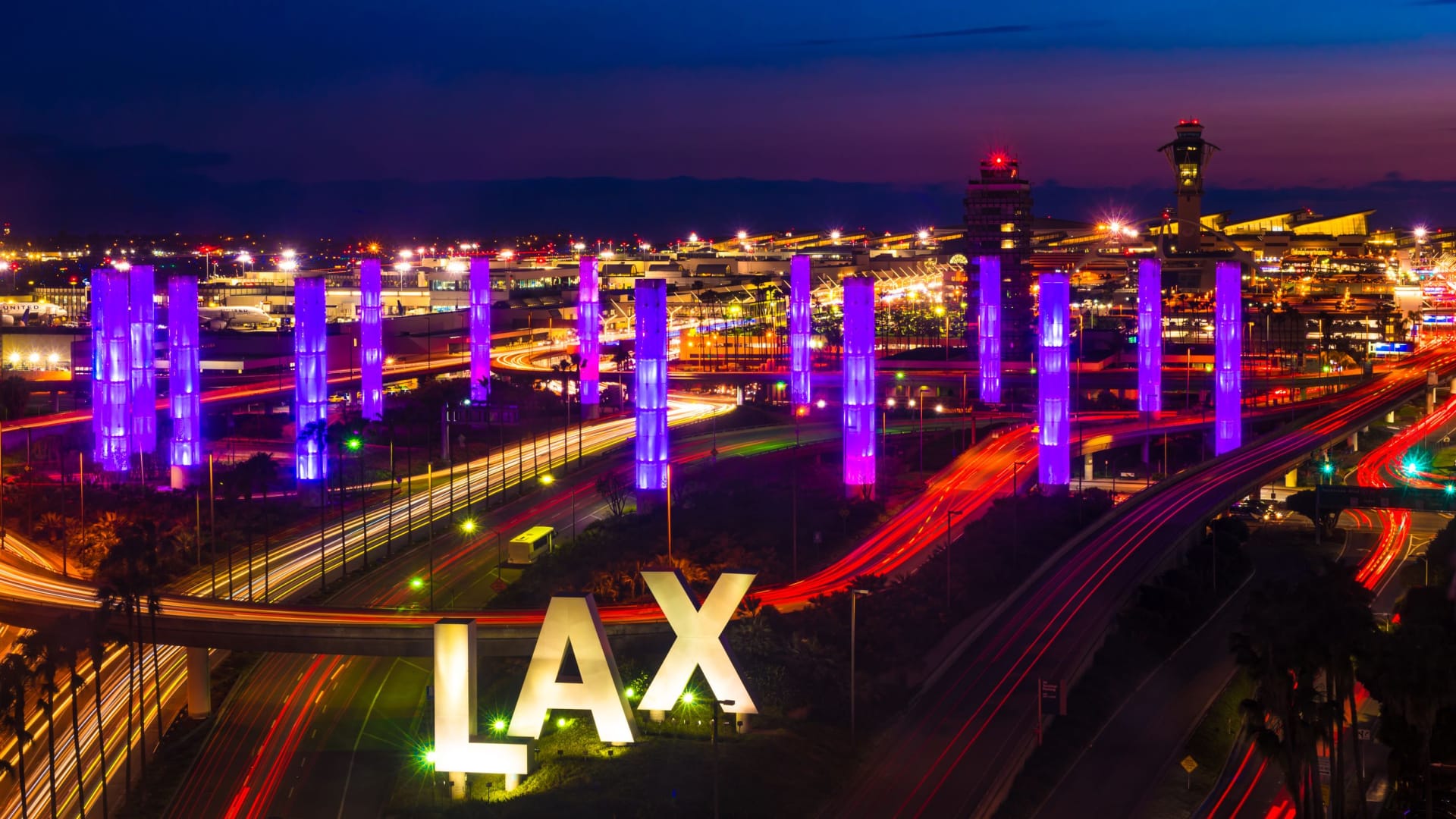 LAX sign outside the Los Angeles airport lit up at night.