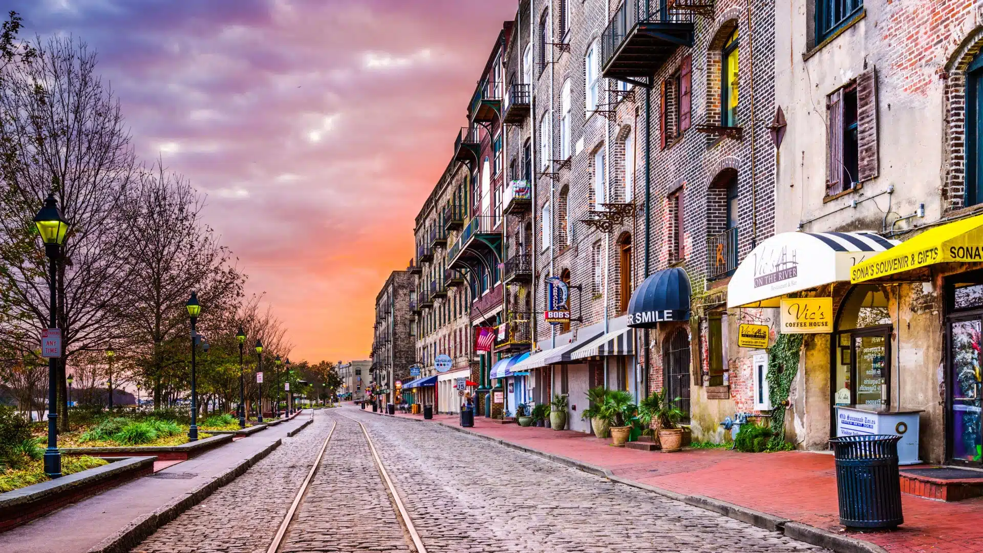 The cobblestone road with rail tracks on it running down River Street in Savannah Georgia. 