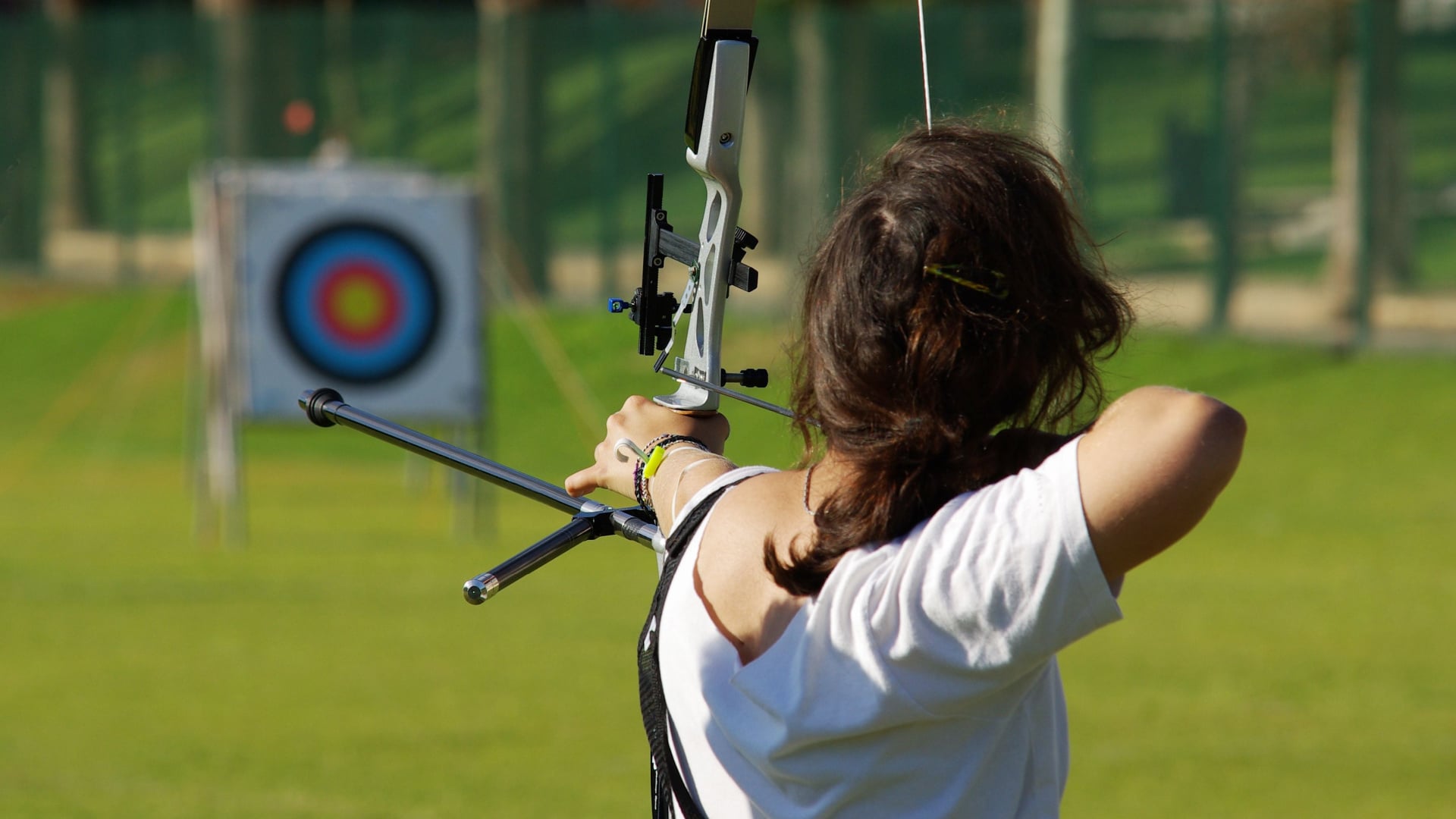 Woman drawing an arrow on an archery course.