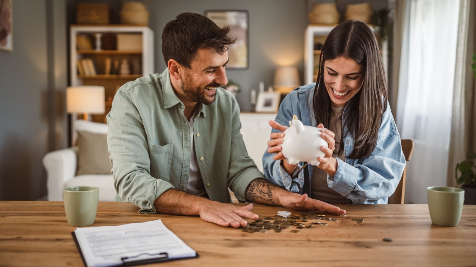 A couple smiling as they count the money in their piggy bank to represent realistic money saving tips.