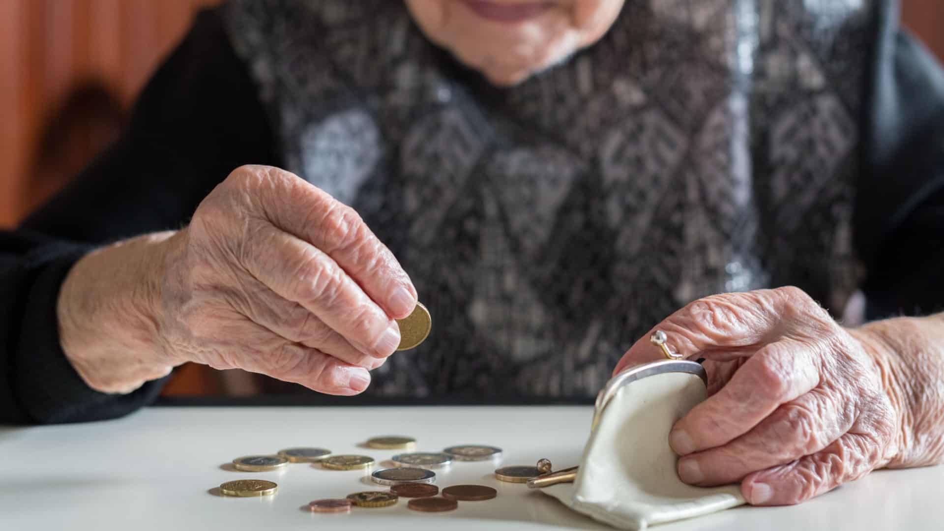 An elderly woman counts the change in her pocketbook.
