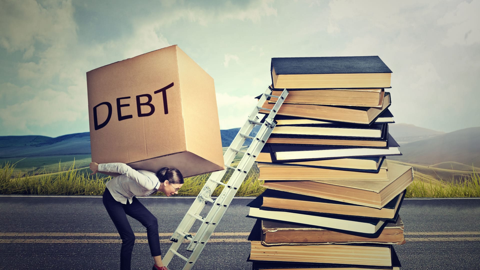 Student loan debt burden concept. Woman struggles to climb a ladder resting on school books while carrying a massive box of debt on her back.