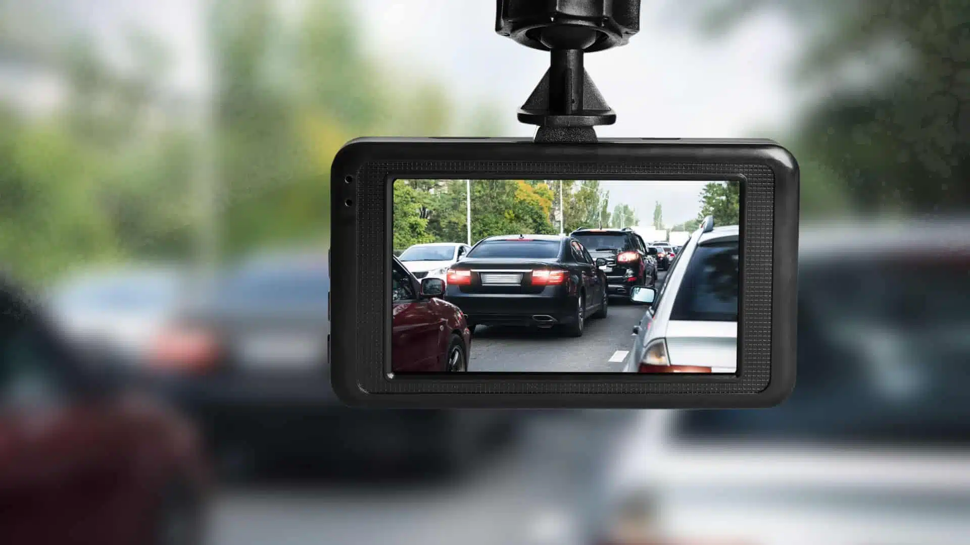 a dashcam mounted near the rearview mirror in a car.