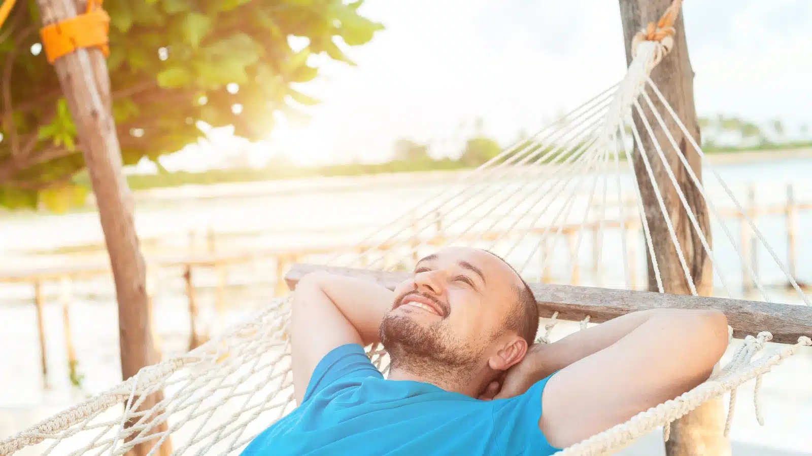 A carefree man relaxes in a hammock.