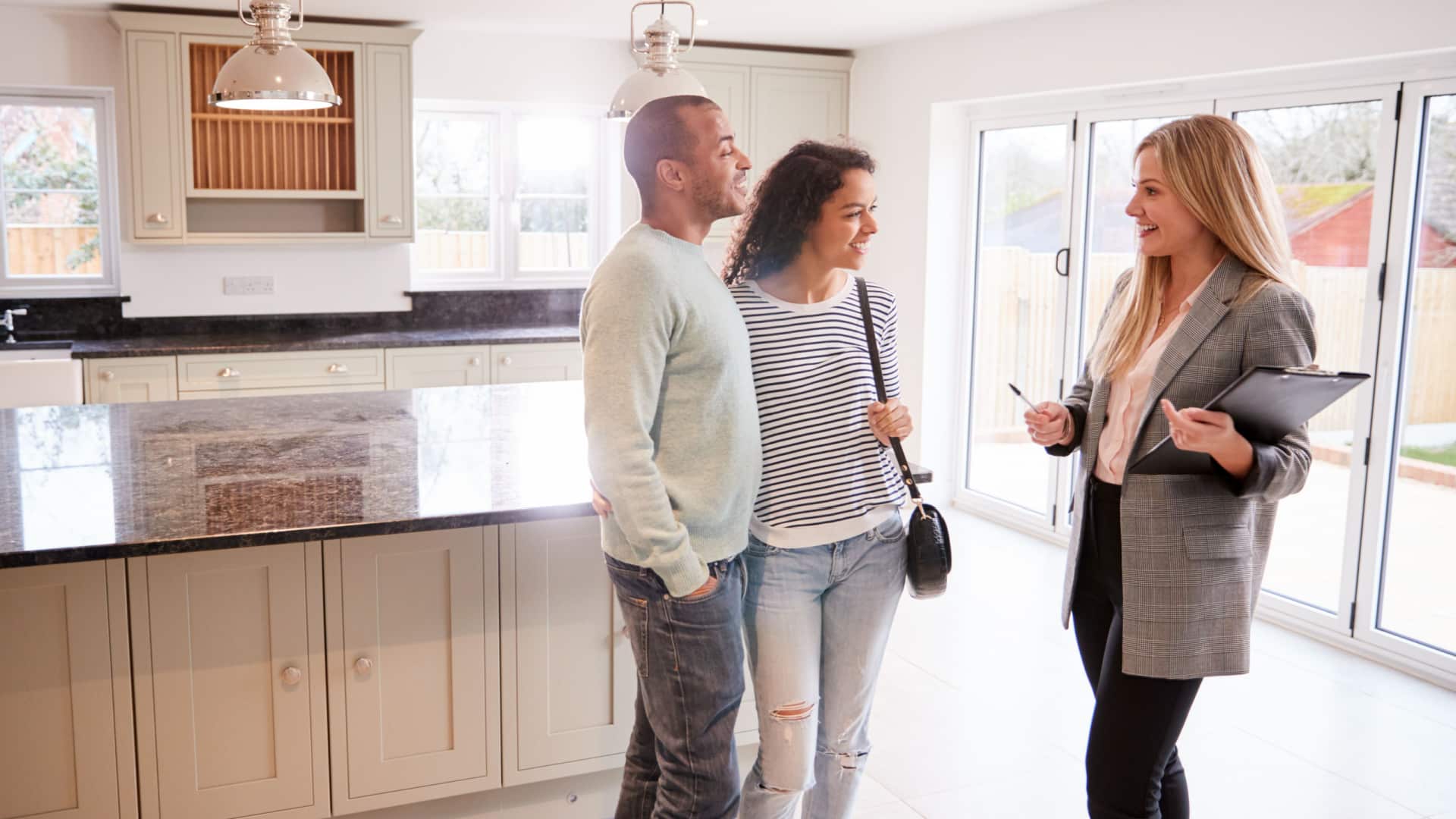 A realtor showing a young couple a house.