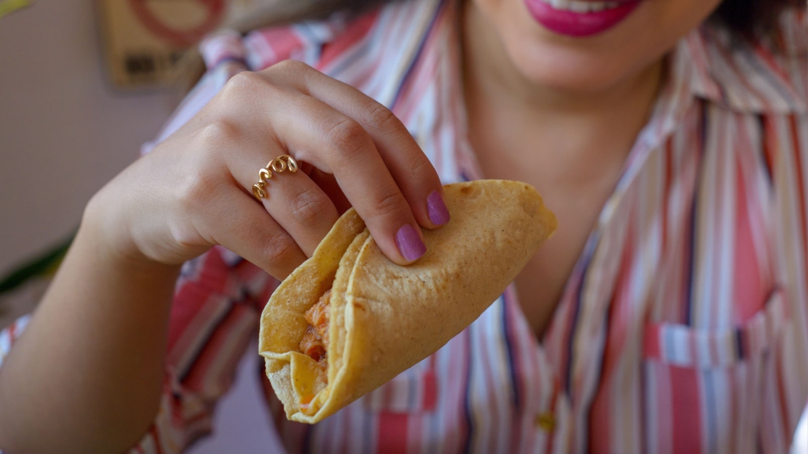 A woman is about to eat a homemade taco.