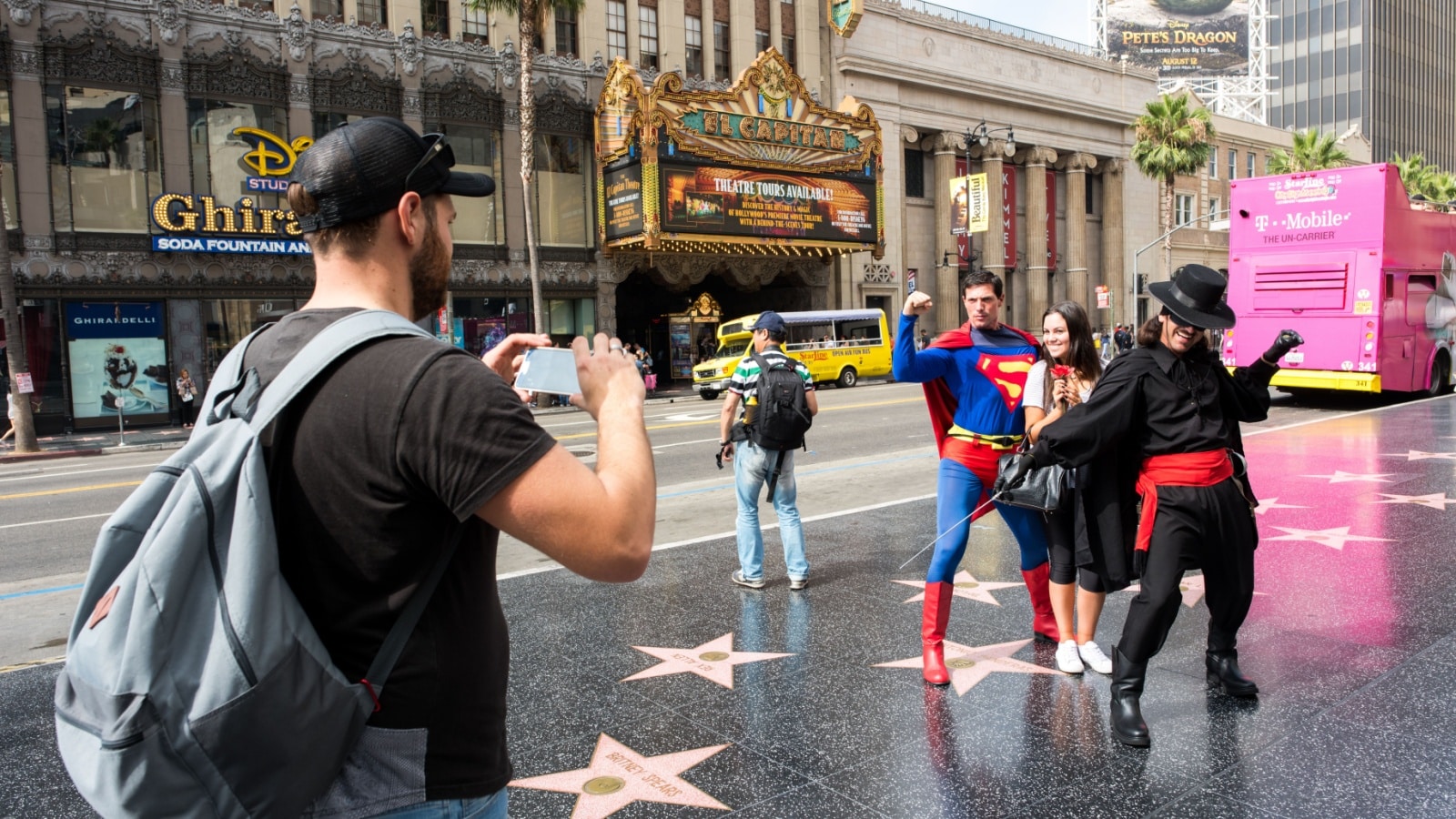 Tourists on Hollywood blvd in Los Angeles taking photos with street performers.