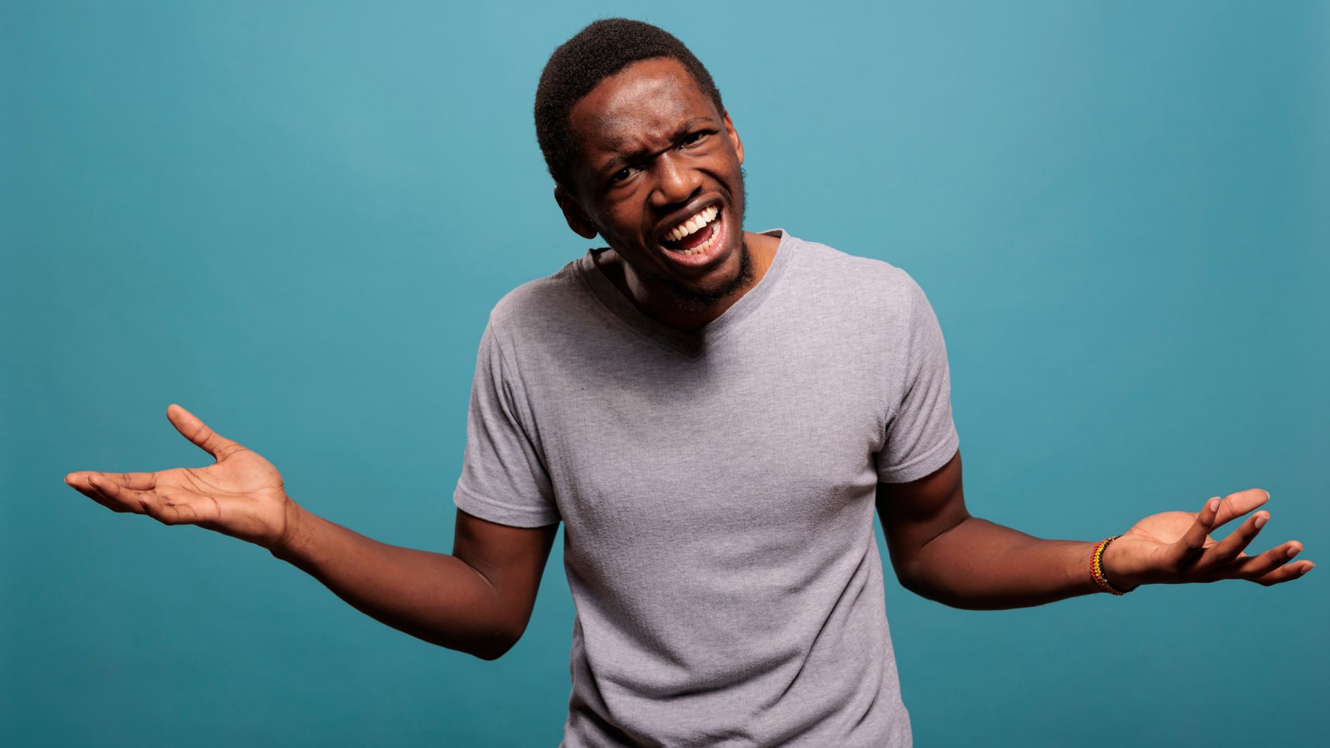 A man has his arms up in outraged confusion.