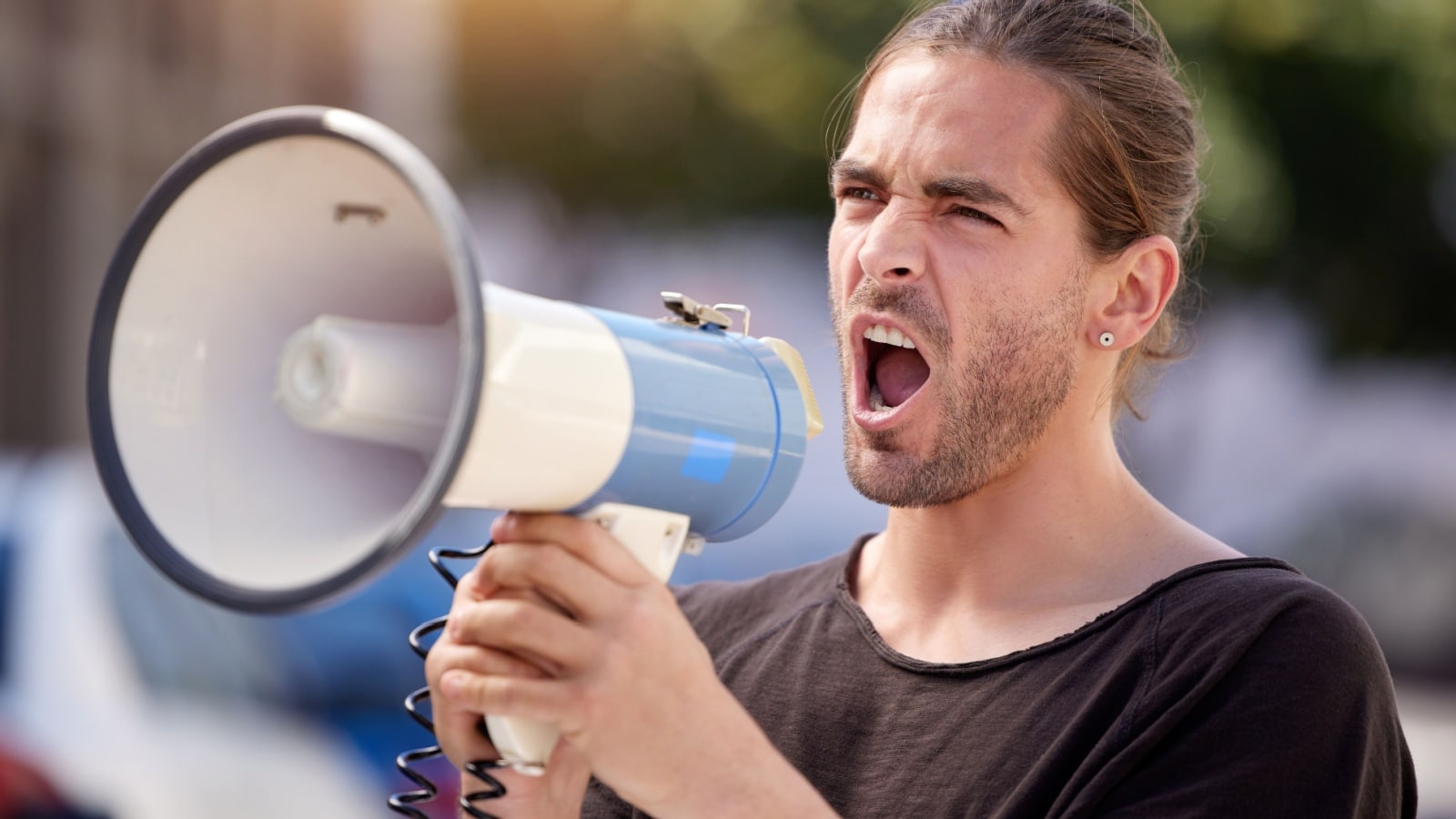 A man holding a megaphone protesting.