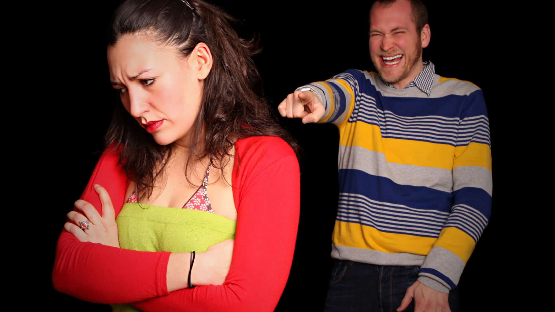 A mean man points and laughs at his girlfriend.