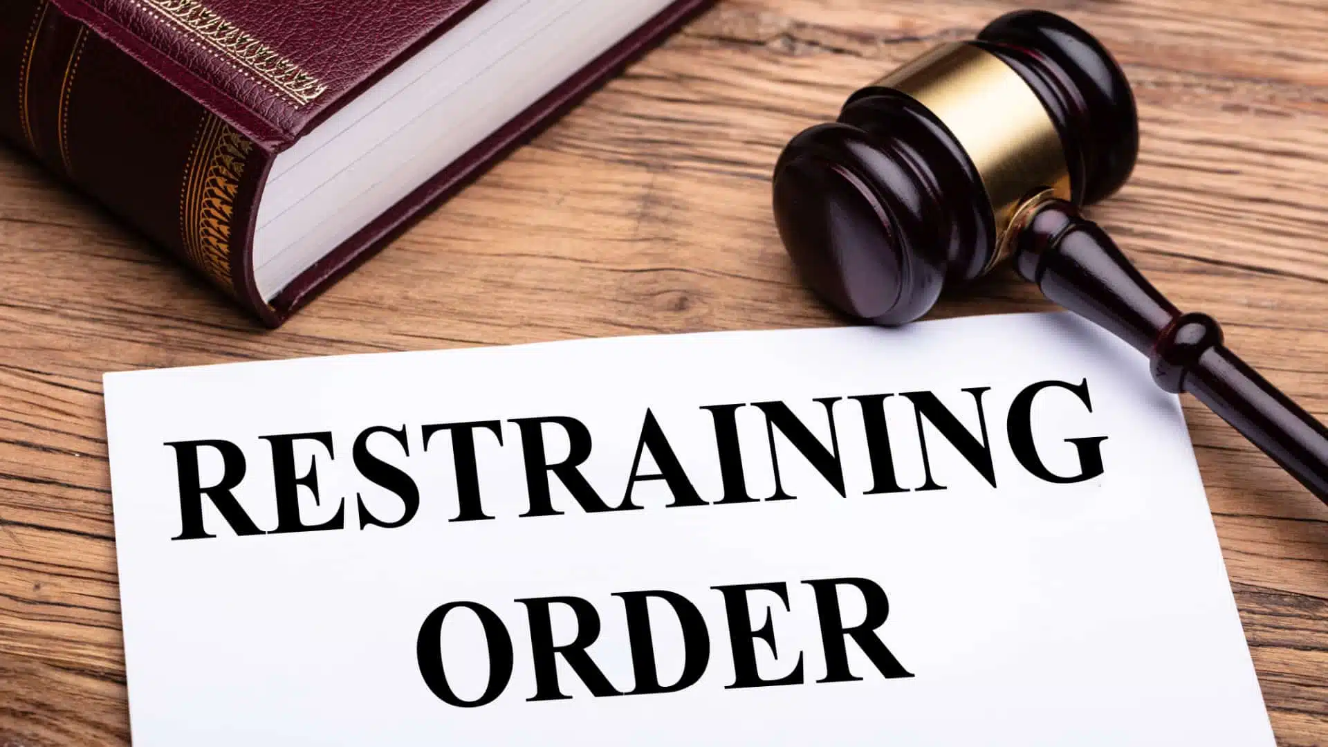 photo of a document with the words "restraining order" written in bold letters across the top on a judge's desk. 