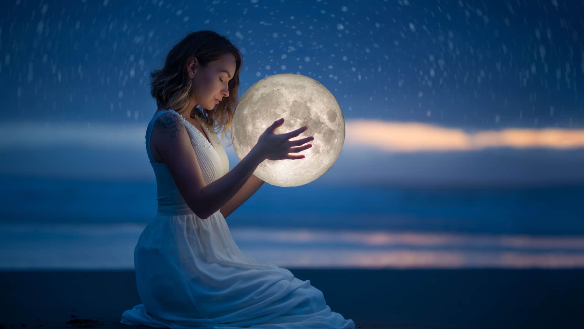A woman holds the moon in her hands to represent moon magic.