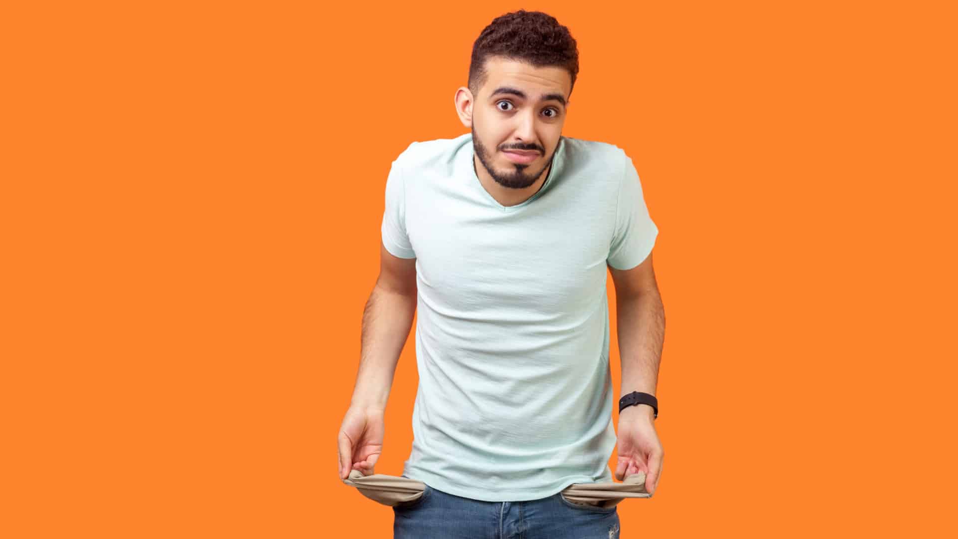 A poor man holds out his empty pockets to show he has no money.